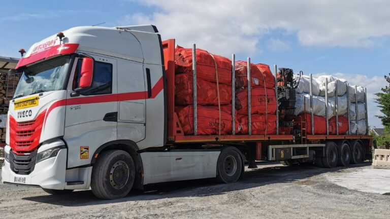 Vrachtwagen geladen met grote zakken brandhout